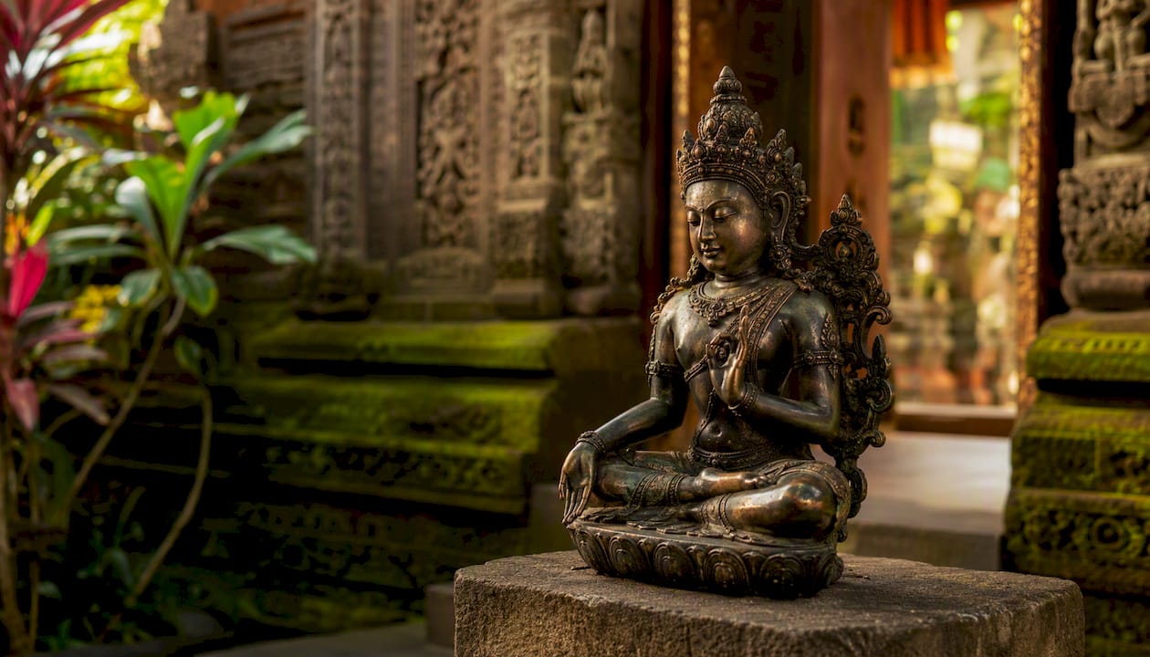 Antique Balinese bronze temple statue on pedestal